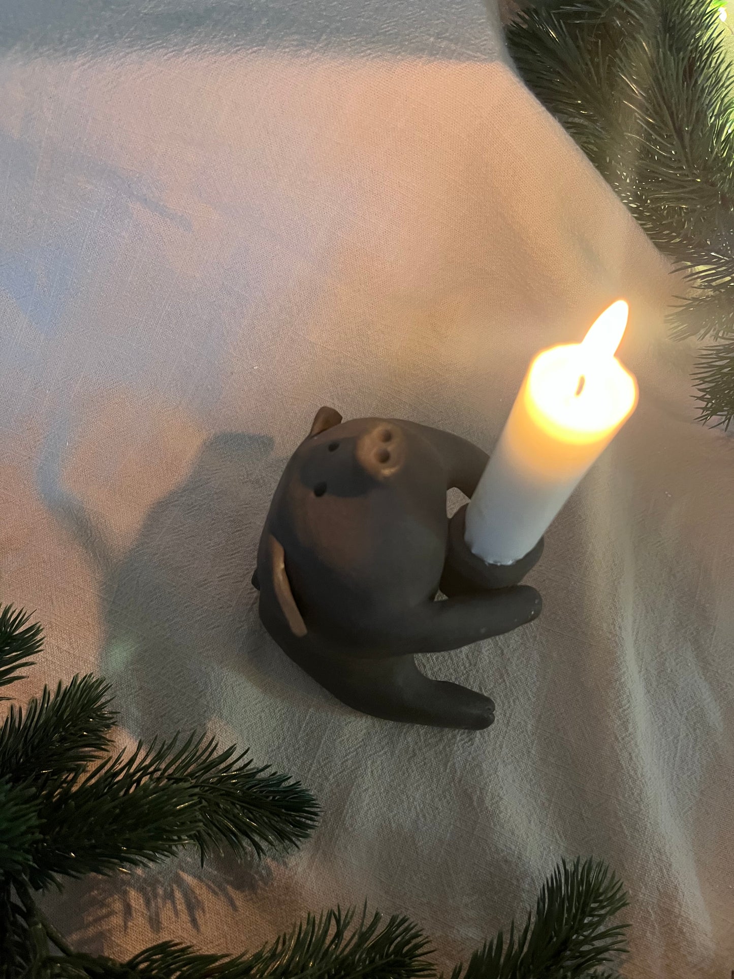 Ljusstake gris sittande