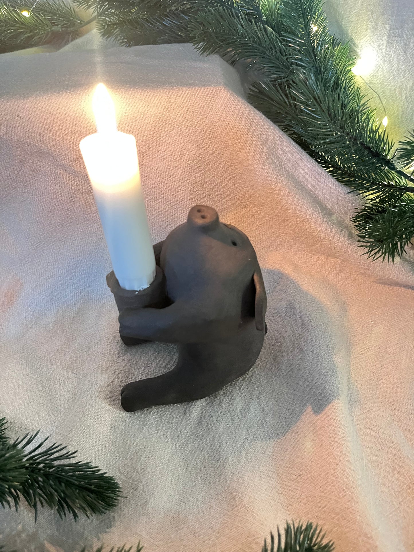 Ljusstake gris sittande